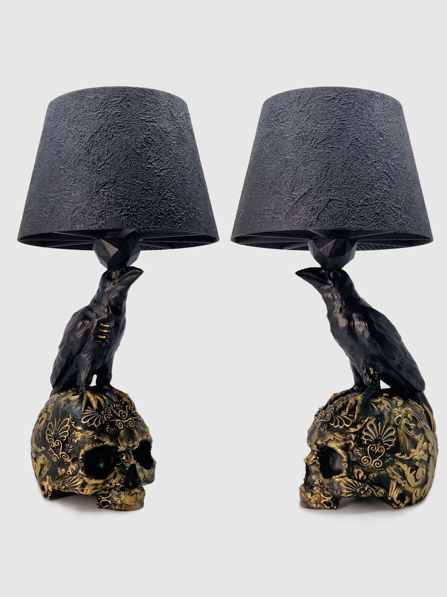 Set of two table lamps with black shades and raven sitting on decorative skulls in a white background, created by Horror Romance