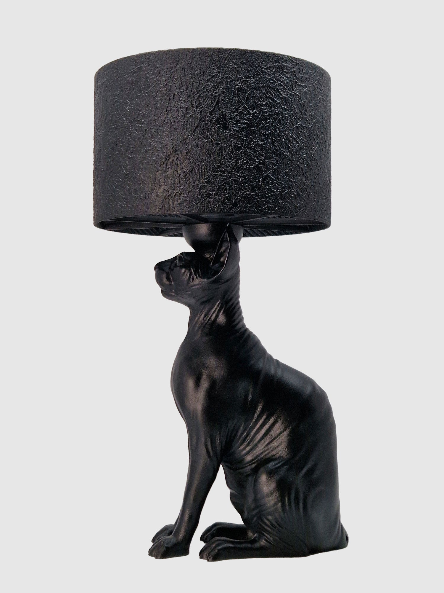 Profile view of the hairless cat lamp base featuring a smooth matte black finish and textured and round shade, designer Horror Romance.