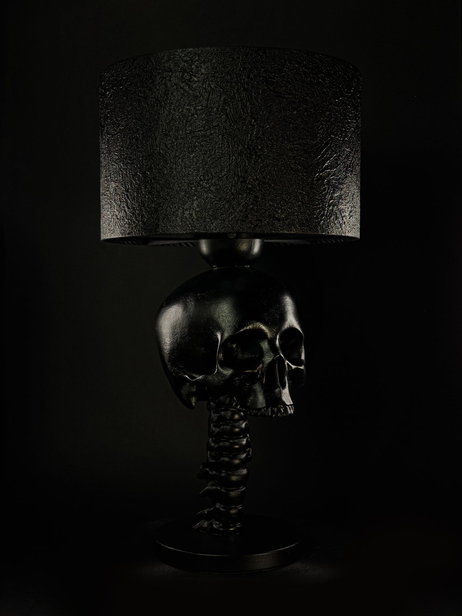 Black Skull Spine sculptural table lamp with textured shade, shown from a three-quarter angle