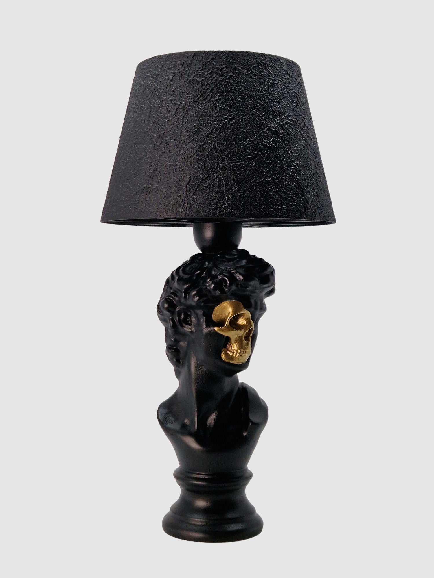 Angled view of the David bust lamp showing the intricate hair texture and the metallic gold anatomical skull detail, Horror Romance design.