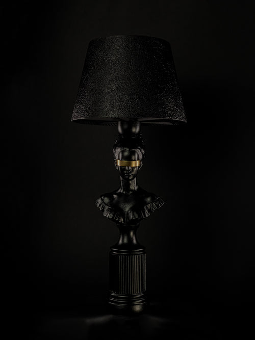 Blind Hera sculptural lamp in satin black with a metallic-gold blindfold, shown from a three-quarter angle