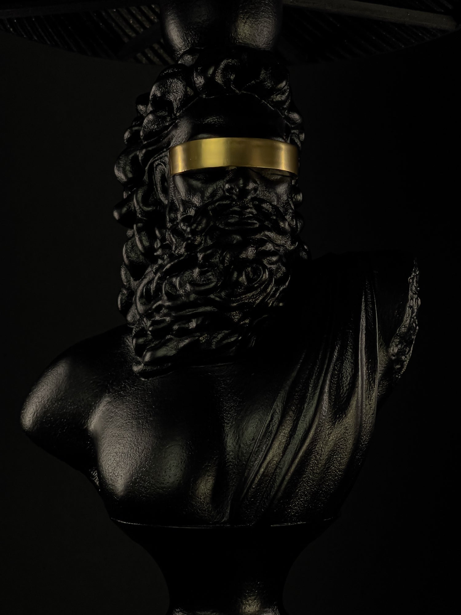 Front detail of the Blind Zeus sculptural lamp with gold blindfold beneath the shade
