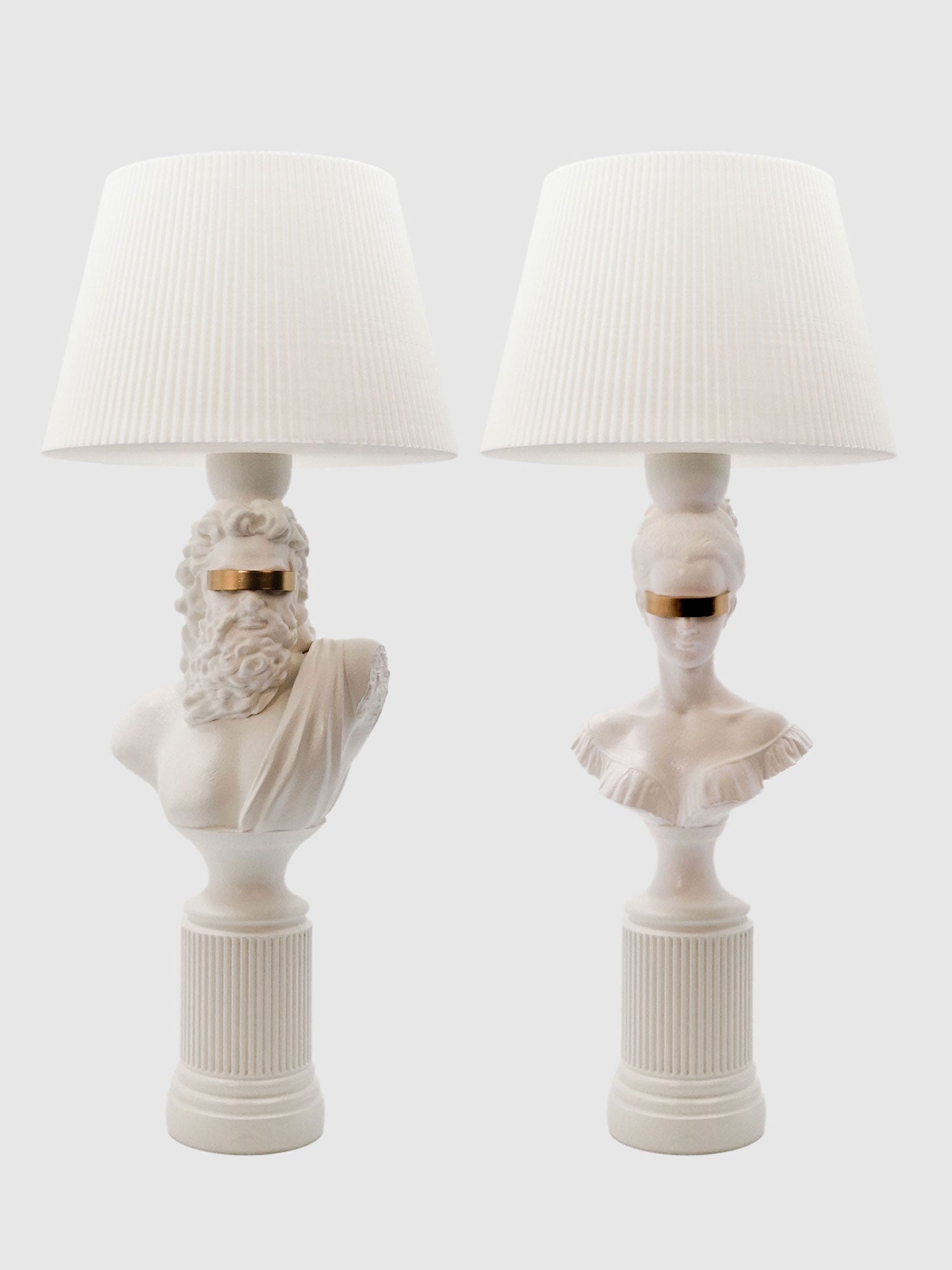 A symmetrical set of Blind Zeus and Hera white and gold classical bust lamps with matching white shades.