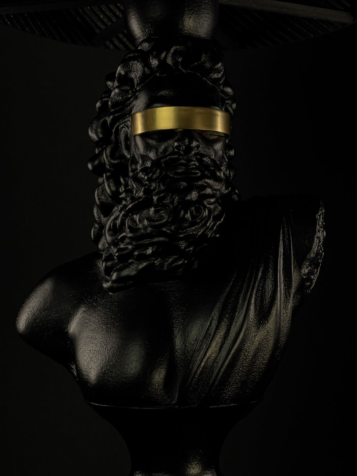 Front detail of the Blind Zeus sculptural lamp with gold blindfold beneath the shade