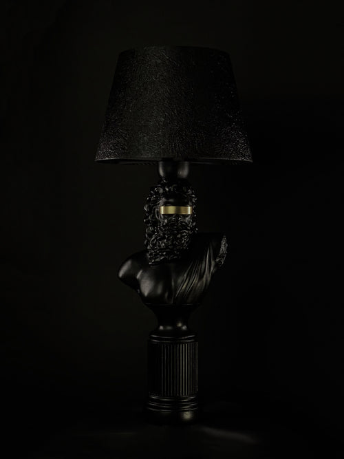 Blind Zeus sculptural lamp in satin black with a gold blindfold and textured black shade