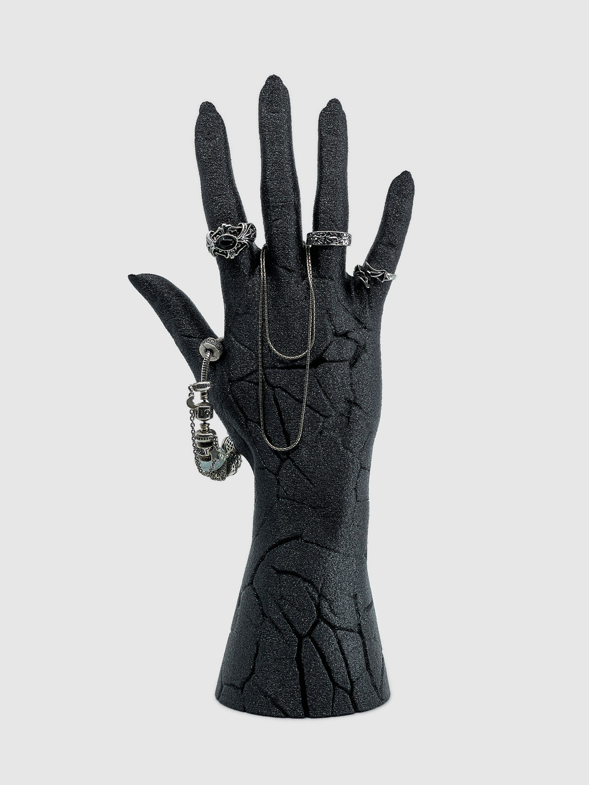 Front view of the Broken Hand jewelry holder in matte black with a shimmering night sky finish and cracked skin texture.