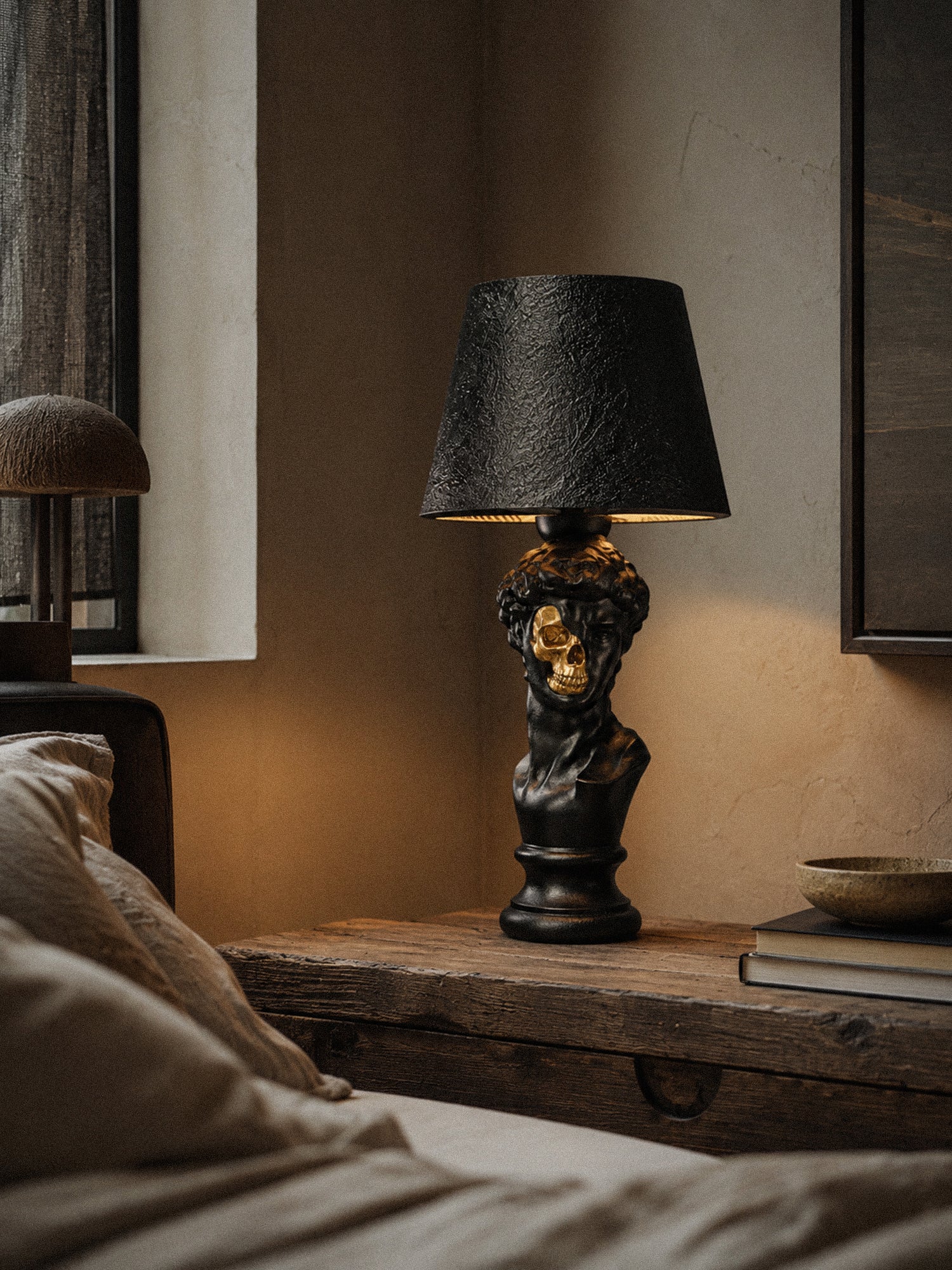 Illuminated David sculptural lamp in a moody bedroom with aged wood and textured walls