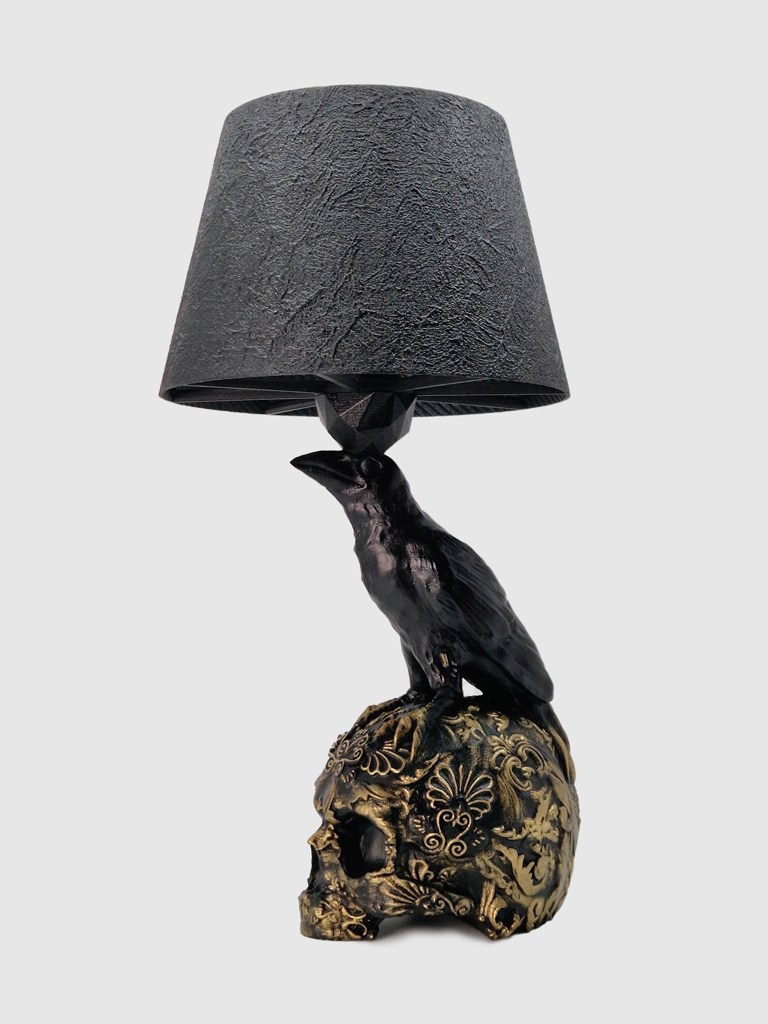 Angled view of the raven lamp base highlighting the metallic gold filigree and anatomical raven details manufactured by Horror Romance.
