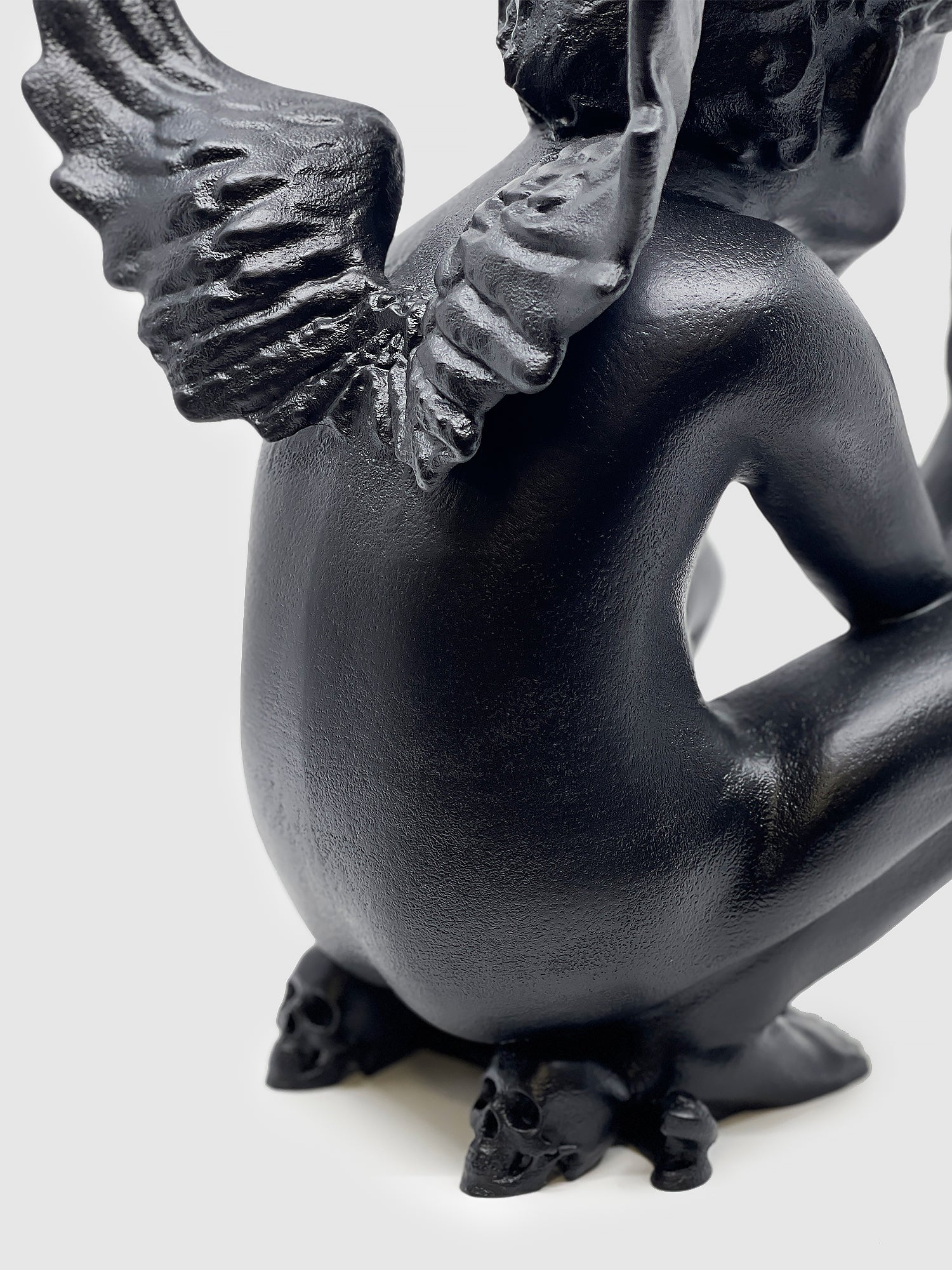 Detailed close-up of the Rebel Angel lamp base featuring miniature black skulls and anatomical wing textures.