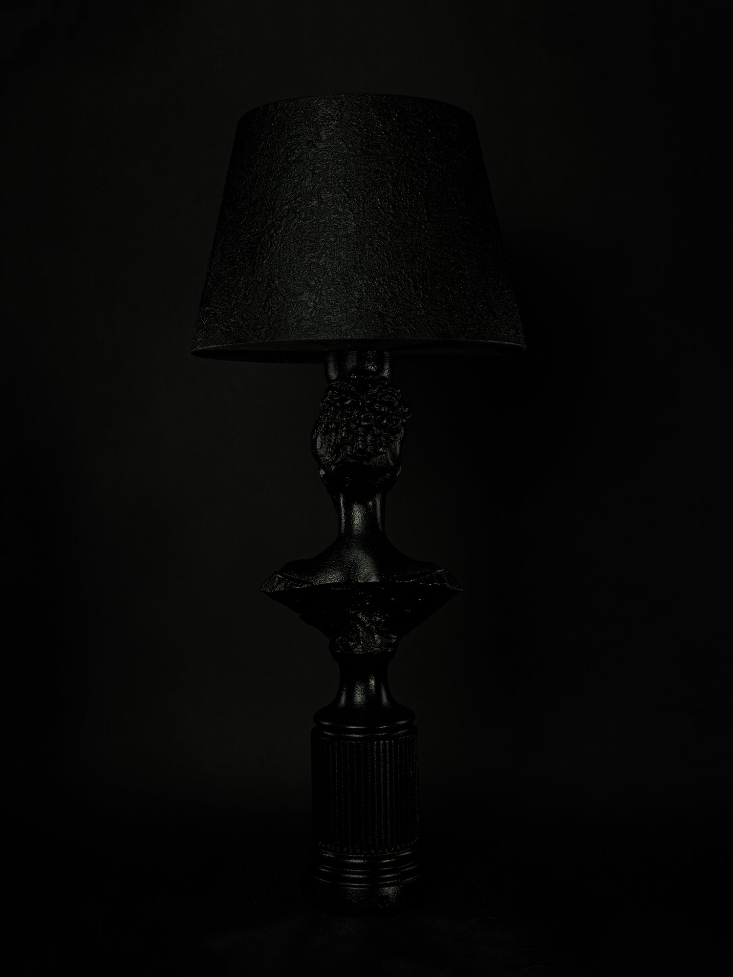 Back view of the satin-black Hera bust lamp and fluted pedestal