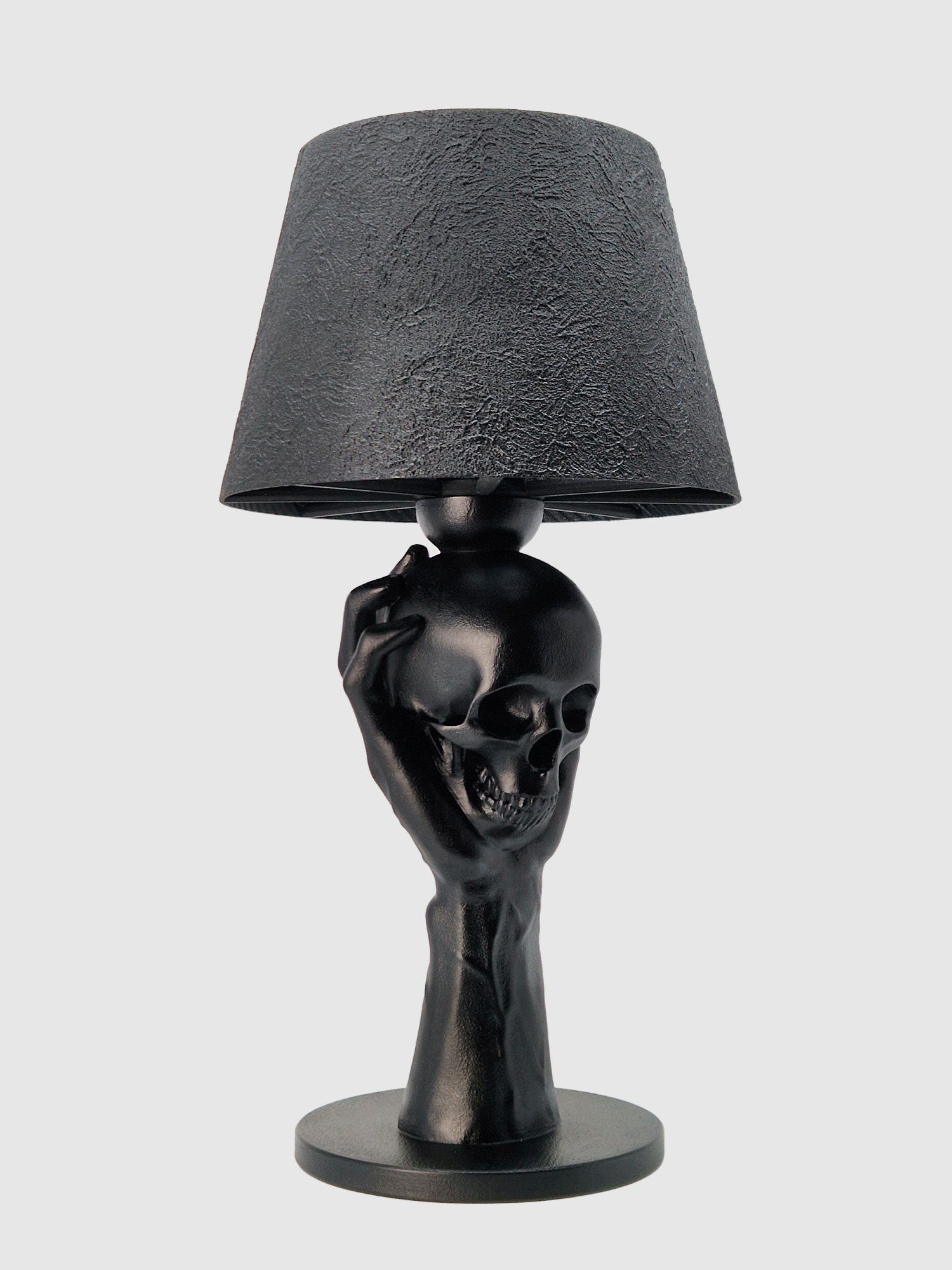 Close-up angled view of the skull and hand lamp base, showcasing the matte black finish and realistic bone textures, original Horror Romance design