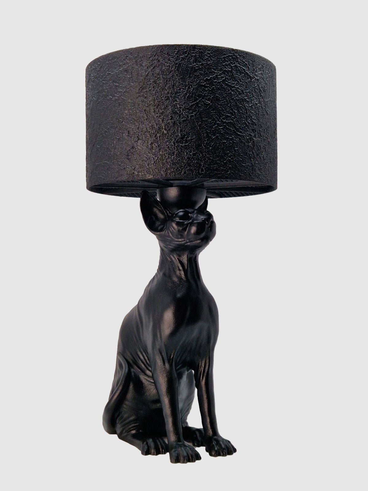 Angled front view of the Purrfect Lamp, a black hairless cat sculpture used as a decorative lamp base, creator Horror Romance.