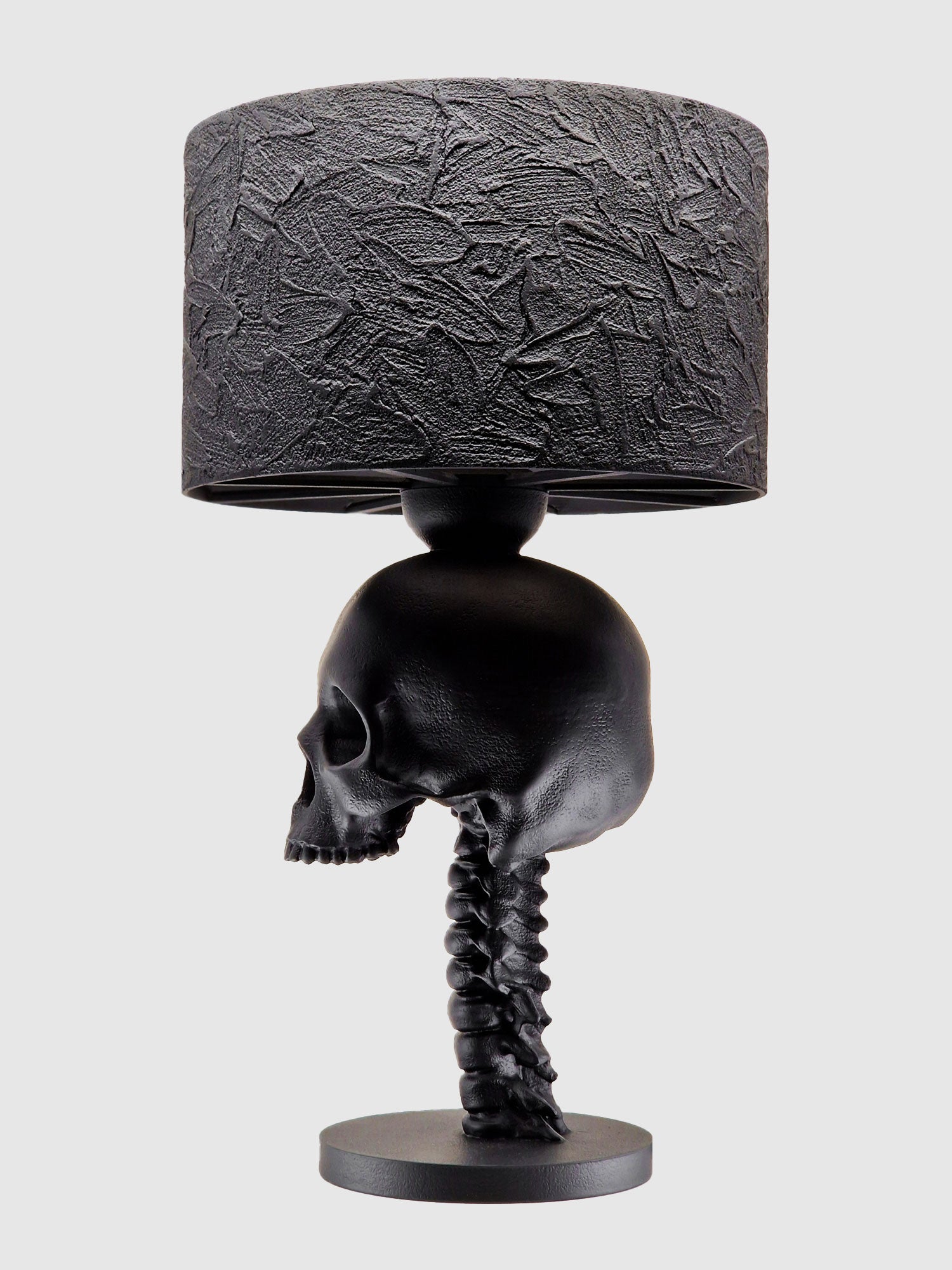 Side view of the Skull Spine lamp showcasing the realistic cranial structure and textured black lampshade, designed by Horror Romance.