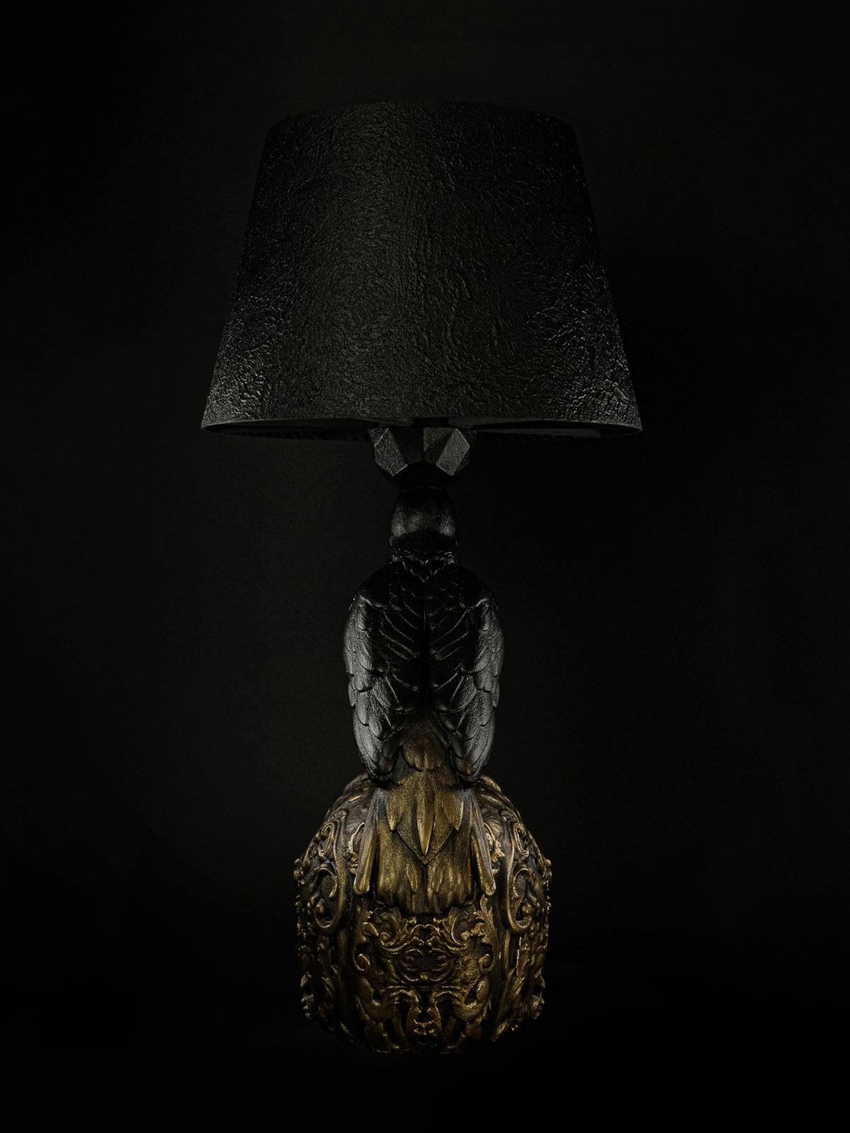Back view of Raven Skull table lamp, showing the raven's tail and gold ornament on the skull.