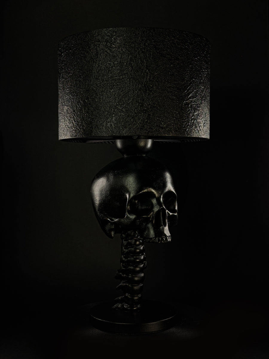 Black Skull Spine sculptural table lamp with textured shade, shown from a three-quarter angle