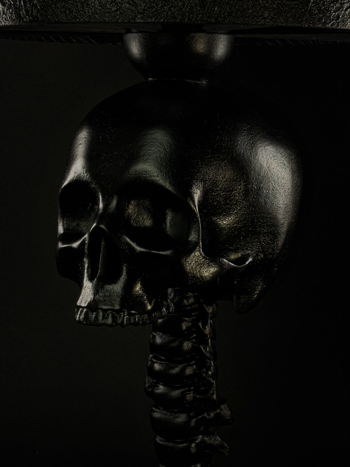 Close-up of the black skull and vertebral spine detail on the Skull Spine table lamp