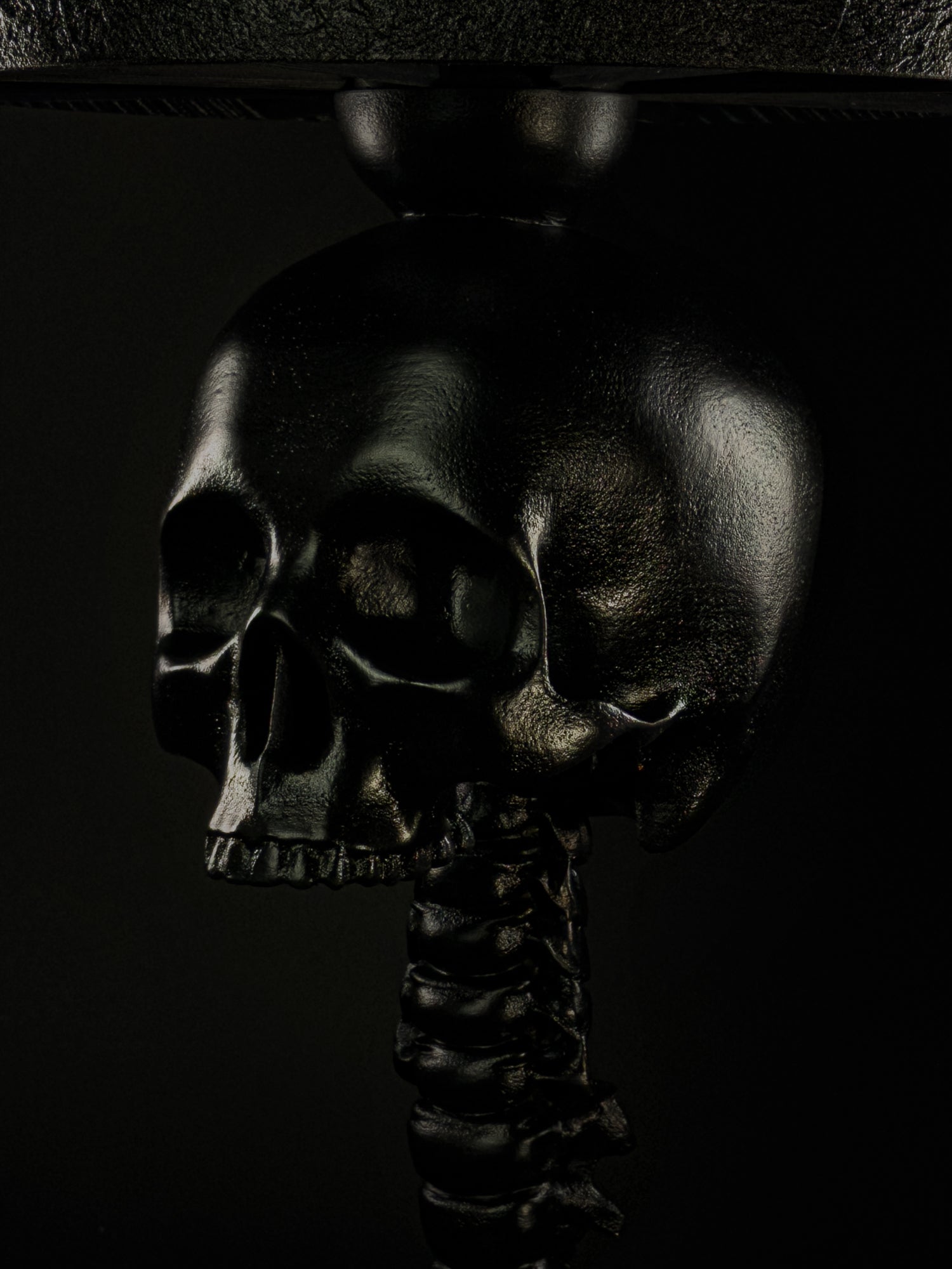 Close-up of the black skull and vertebral spine detail on the Skull Spine table lamp