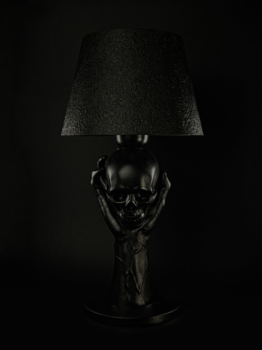To Be or Not To Be sculptural lamp with a black hand raising a skull