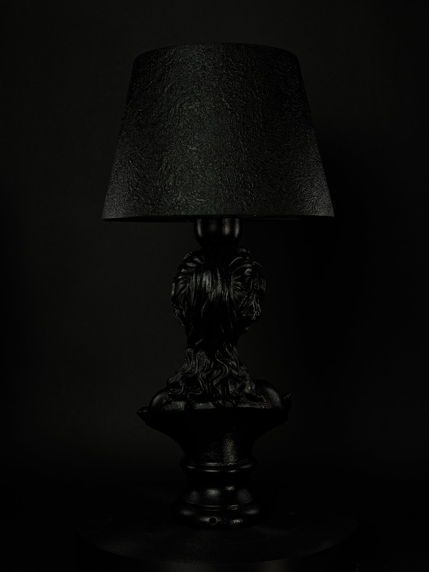 Back view of the satin-black Venus bust lamp and textured shade