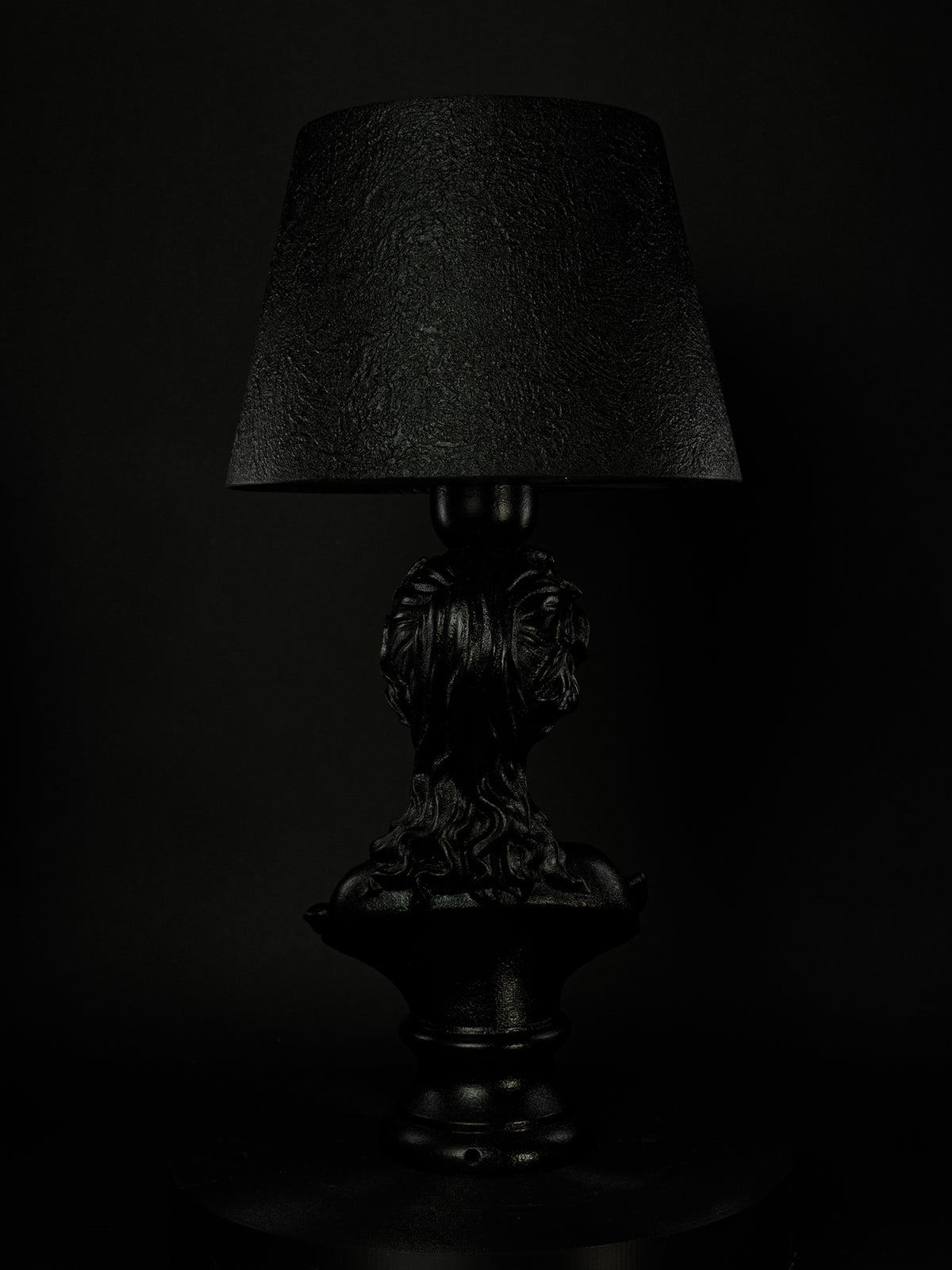 Back view of the satin-black Venus bust lamp and textured shade