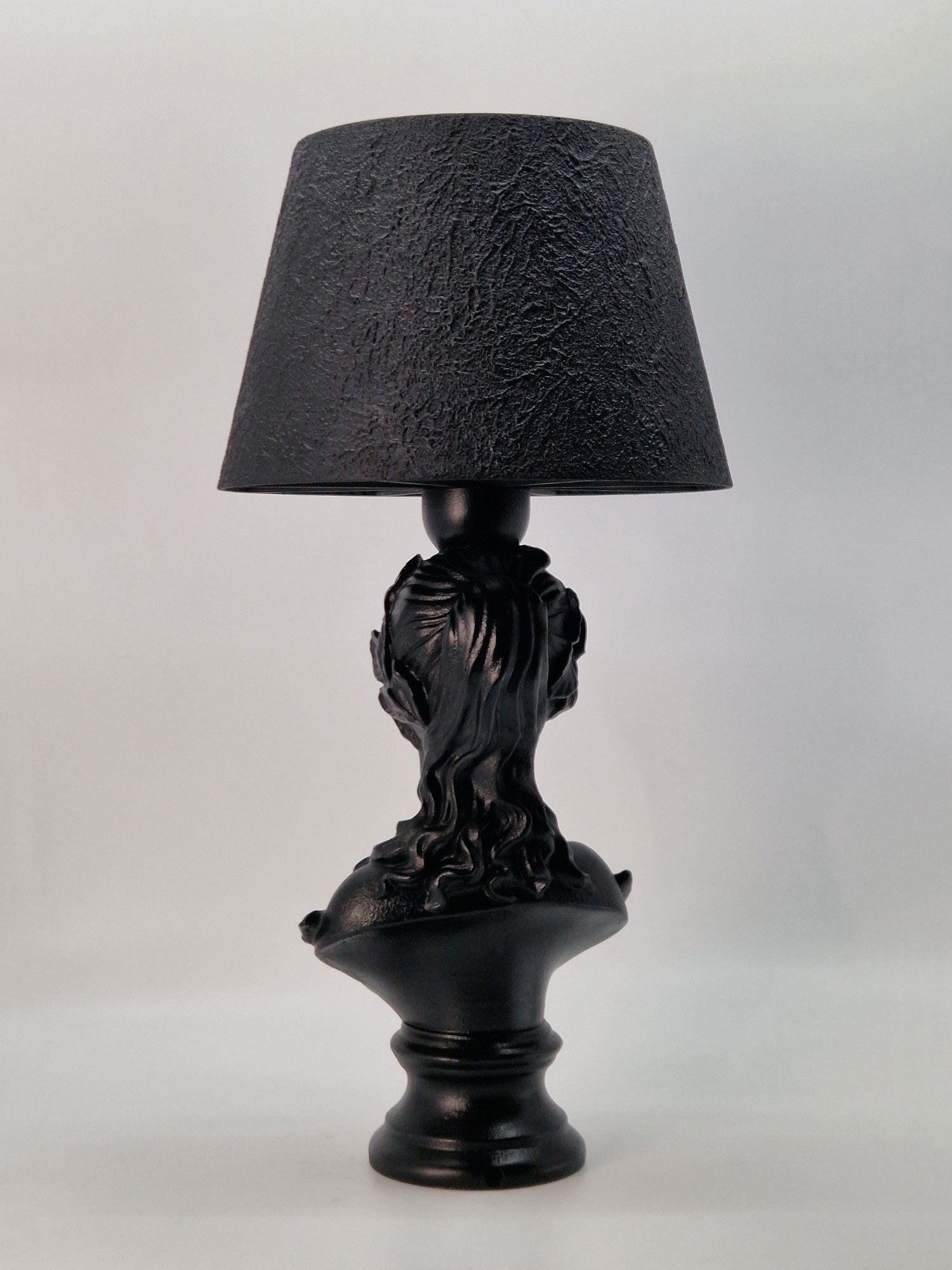 Rear view of the Venus goddess bust lamp featuring intricate hair details and a fluted pedestal base.