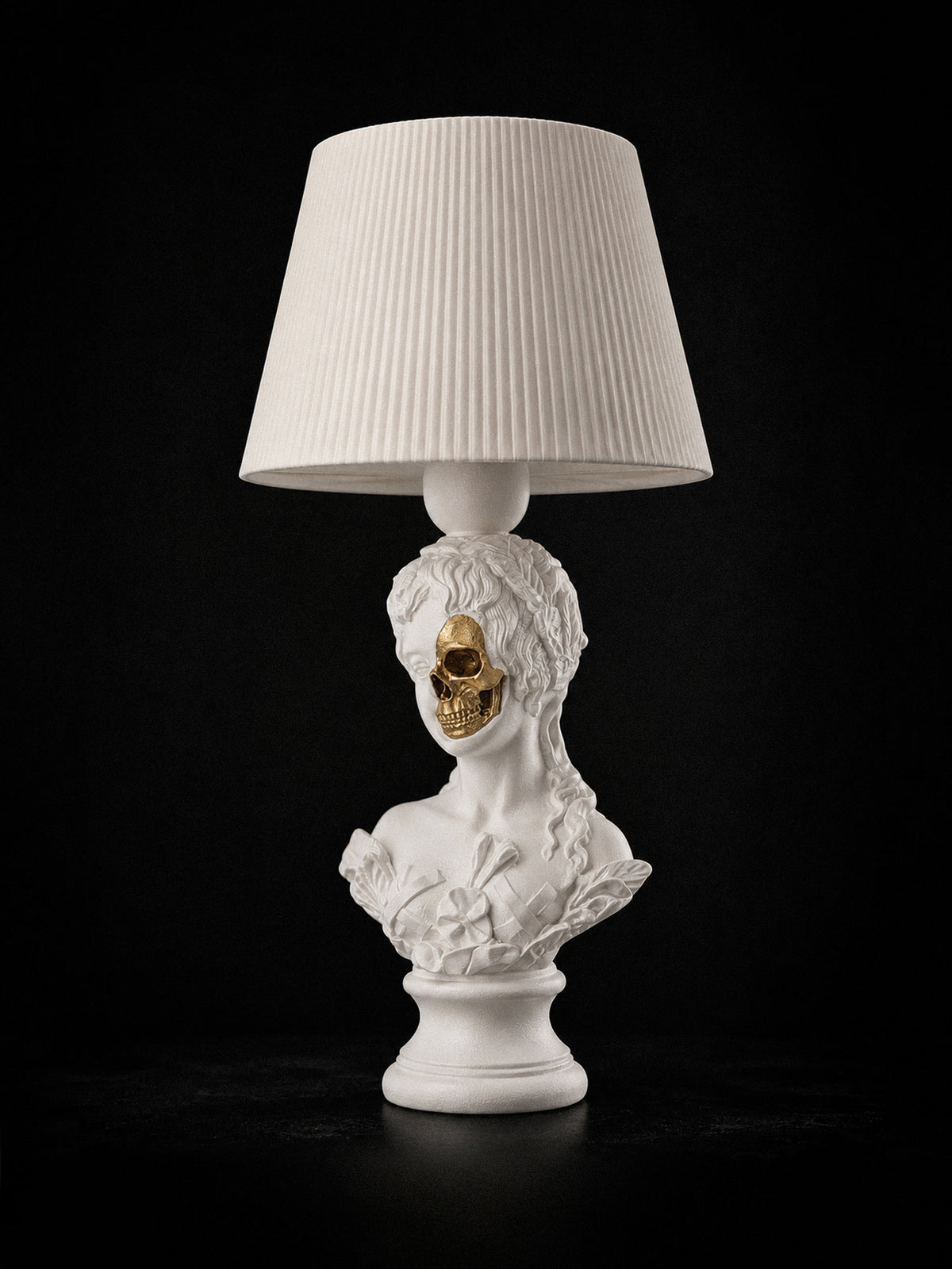 White Venus sculptural lamp with exposed metallic-gold skull and white pleated shade