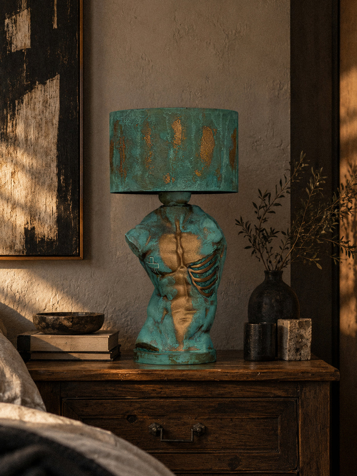 Verdigris Body Adam lamp on a wooden console beside books and a dark vase
