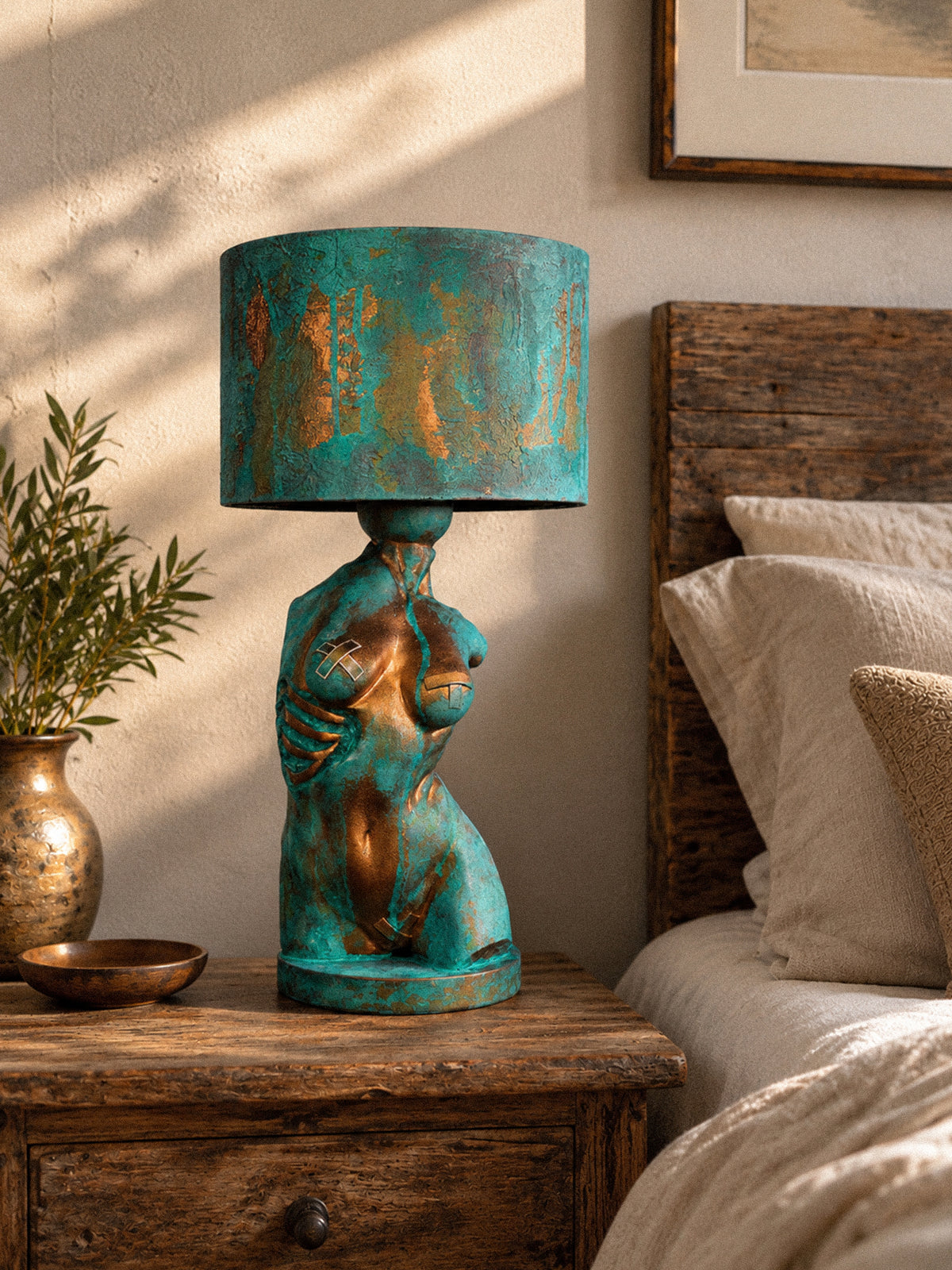 Verdigris Body Eve lamp on a wooden bedside table beside cream bedding in daylight