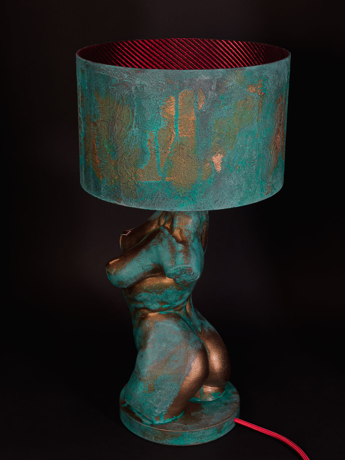Rear three-quarter view of Verdigris Body Eve showing the sculpted back, copper patina and red cable