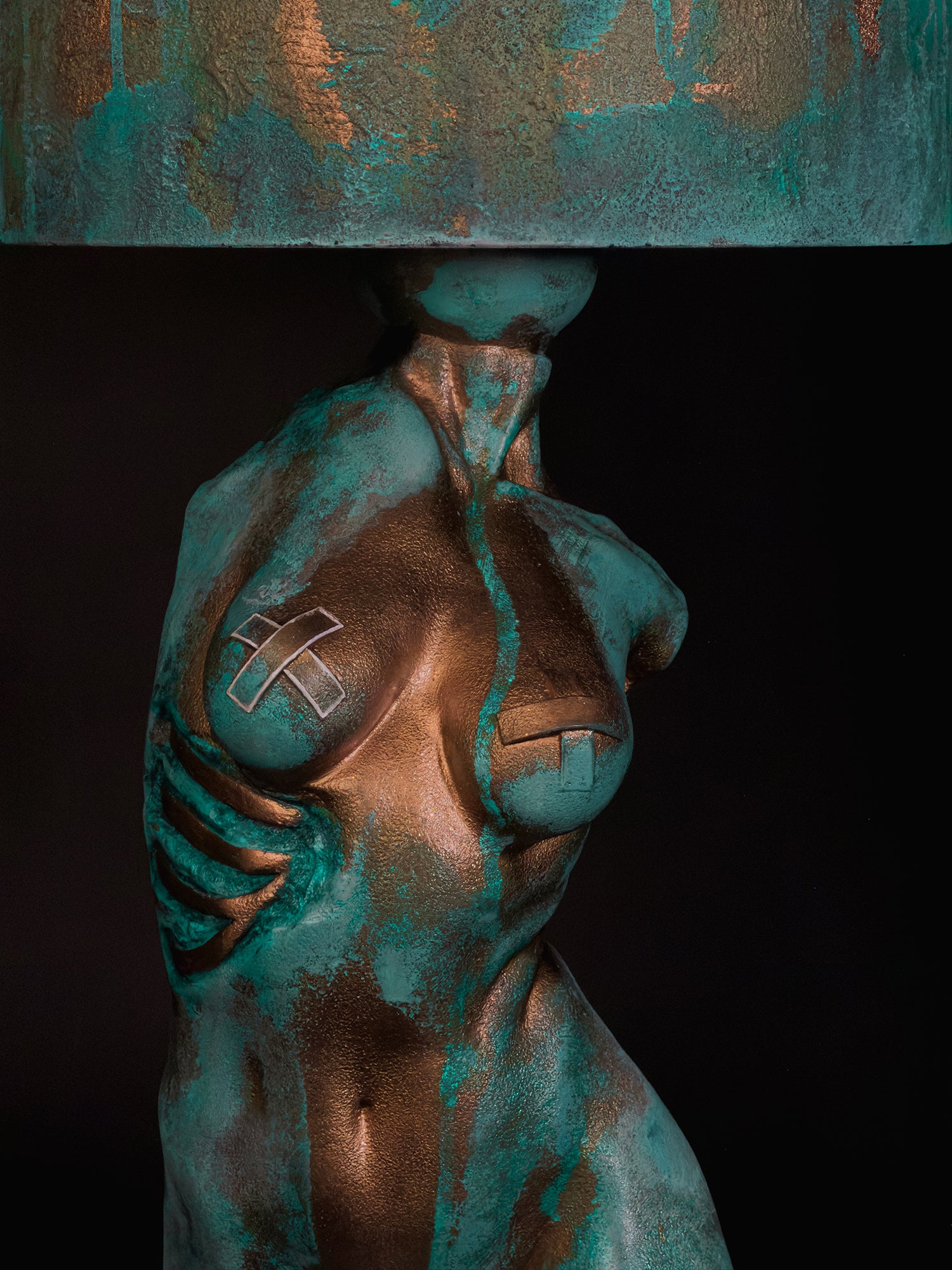 Close-up of Verdigris Body Eve showing textured copper, turquoise patina, crossed chest details and exposed ribs