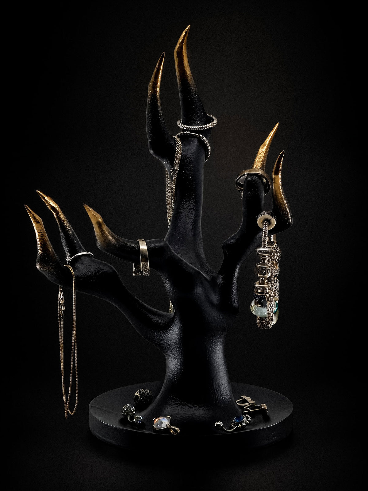 Front view of Vestige jewelry stand with branching black fingers, gold tips and jewelry on the round tray.