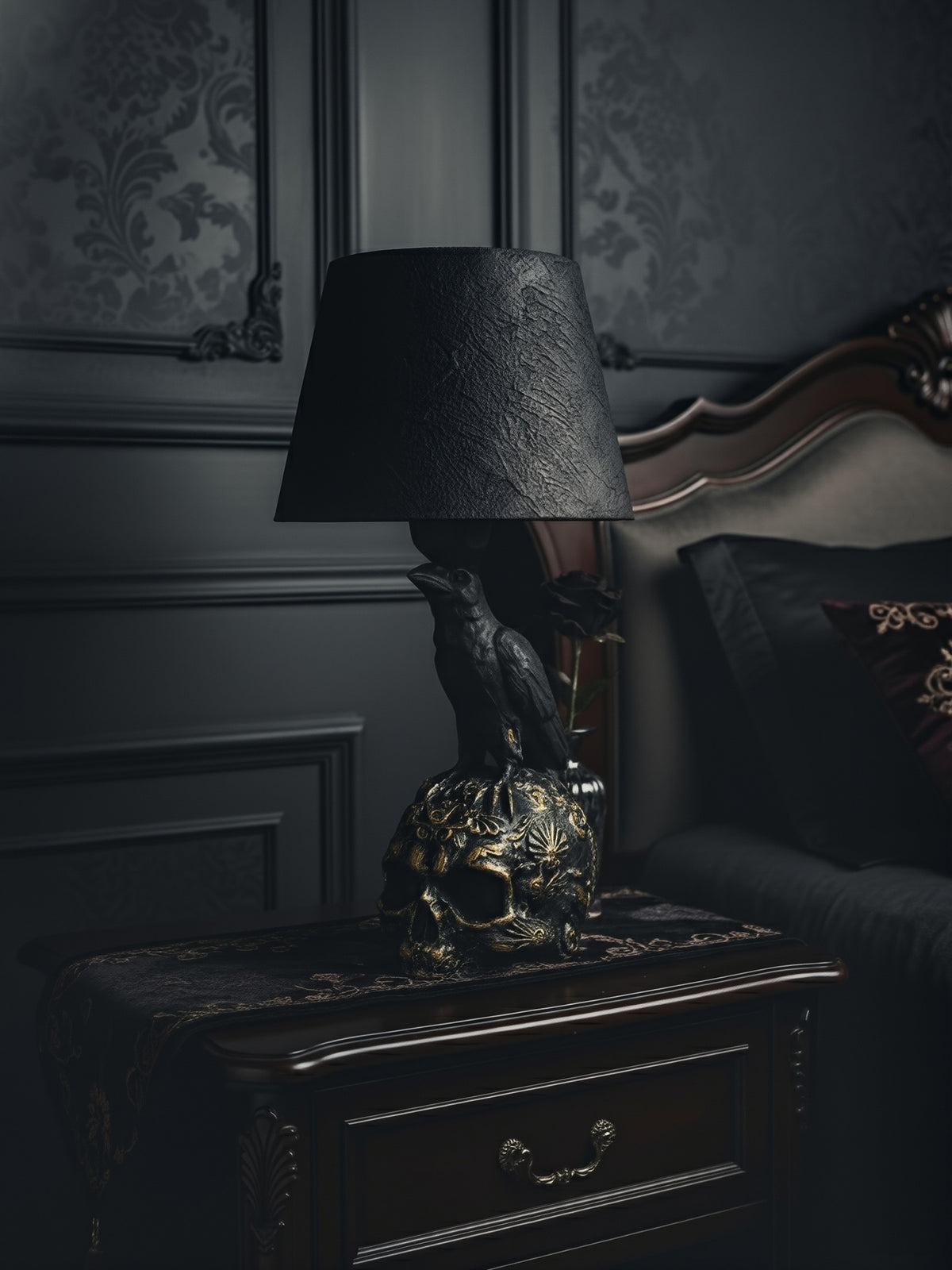 The Raven Skull lamp styled on a dark mahogany nightstand in a luxurious Victorian Gothic bedroom.