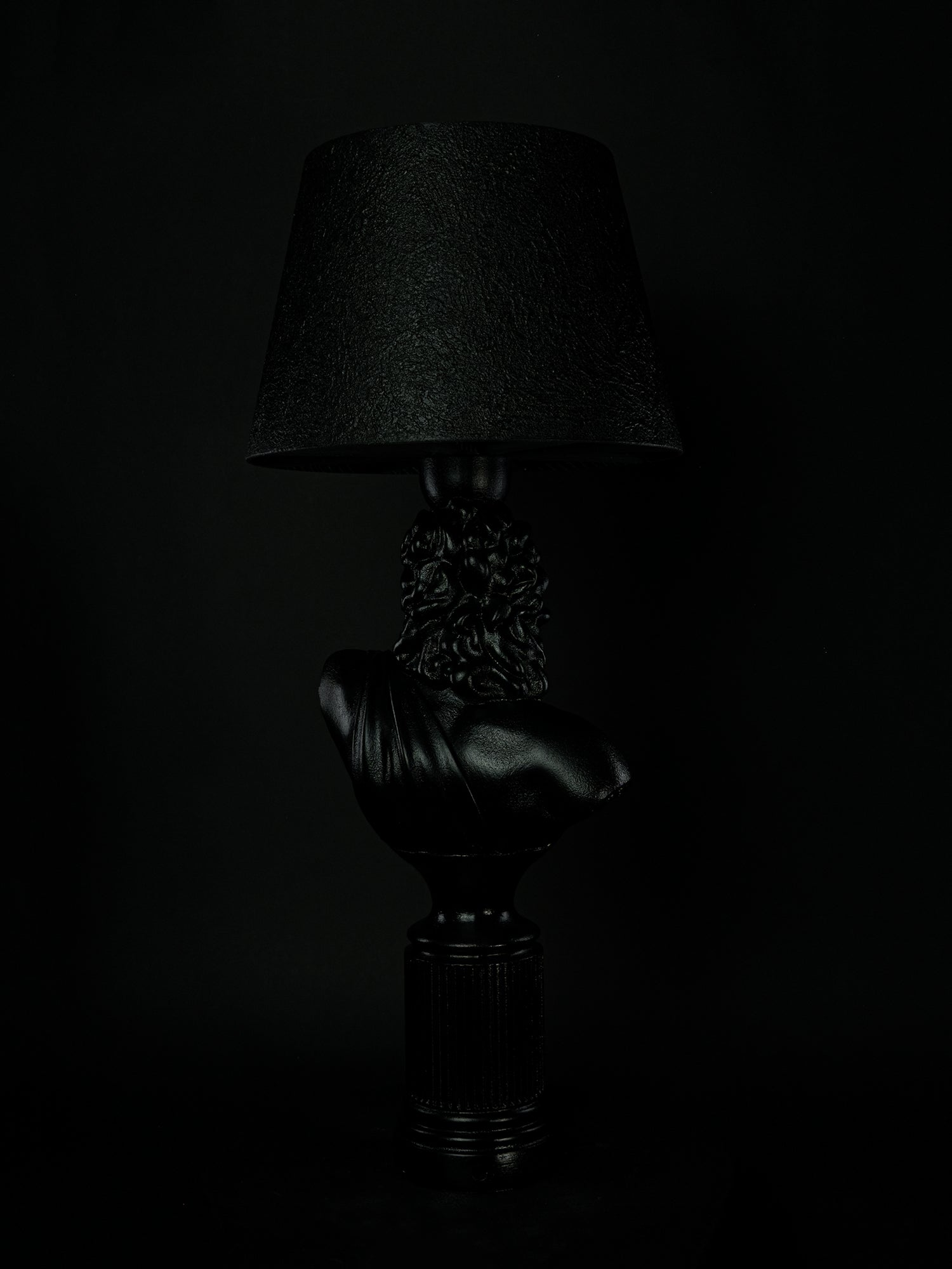 Back view of the satin-black Zeus classical bust lamp and fluted pedestal