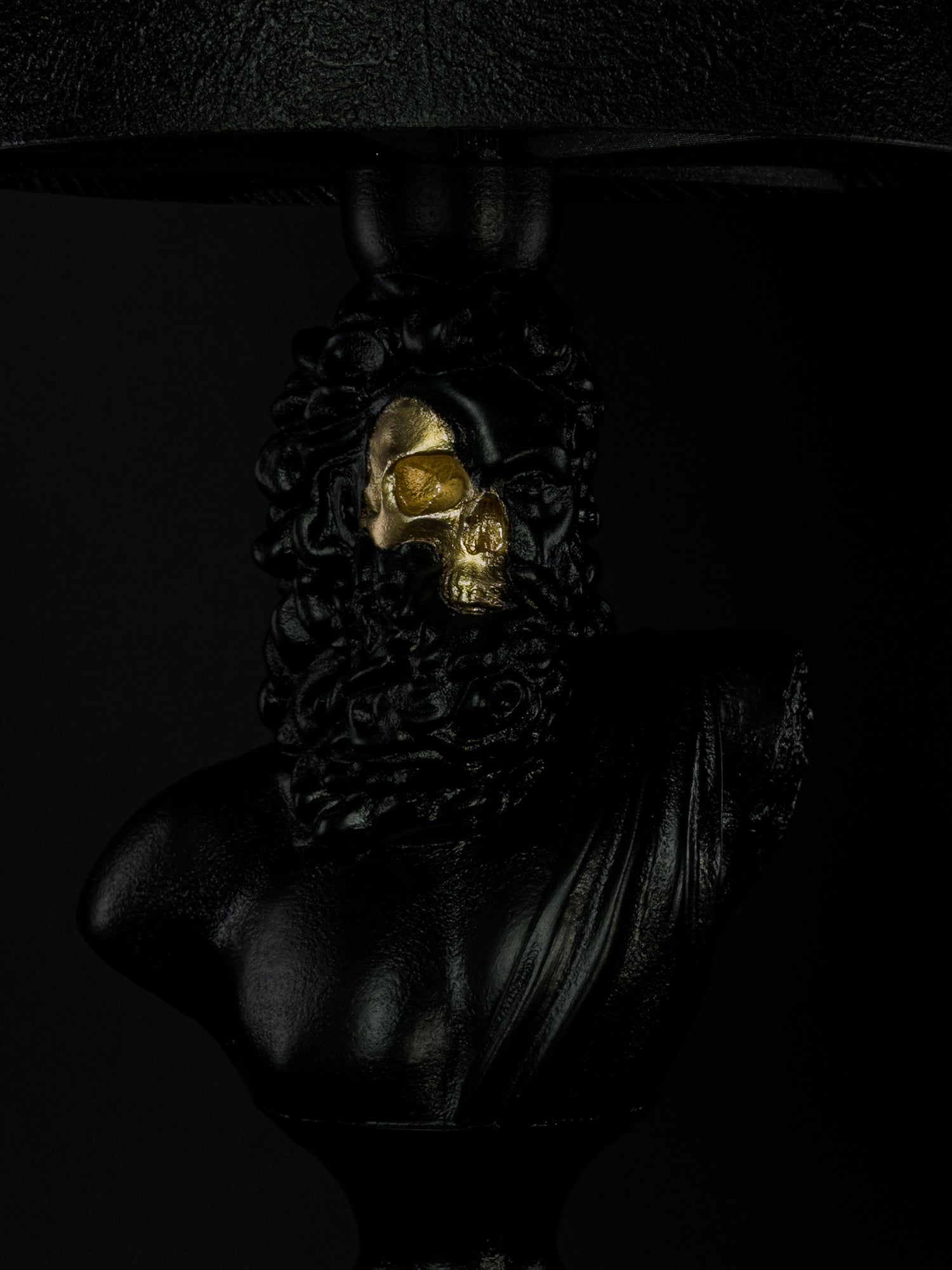 Close-up of Zeus’s exposed gold skull, beard and hand-finished black surface