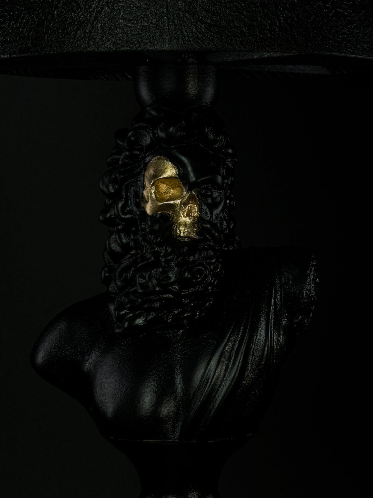 Close-up of Zeus’s exposed gold skull, beard and hand-finished black surface